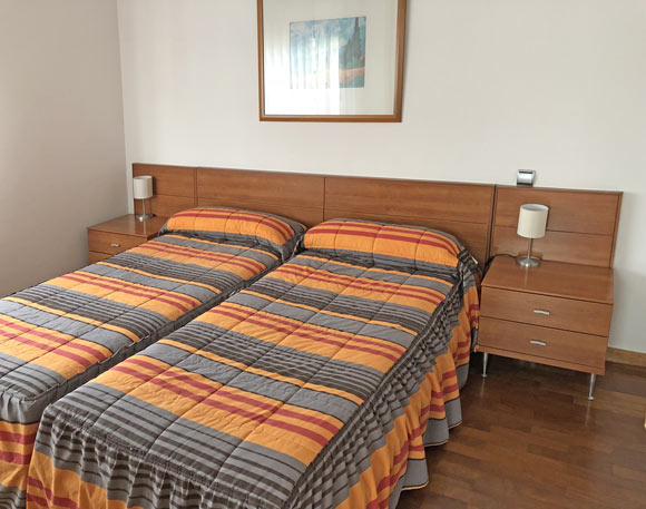 Fotografía de dormitorio con dos camas Apartahotel Ribera